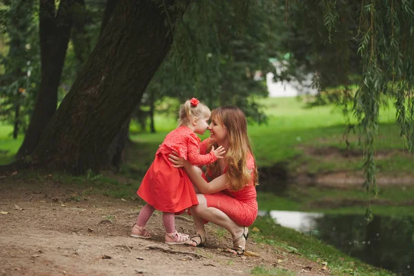 Happy mother with daughter in red dresses — Stock Photo, Image
