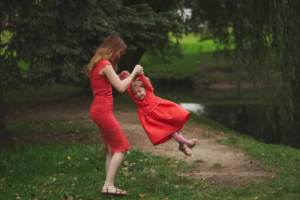 Ευτυχισμένη μητέρα με την κόρη της σε κόκκινα φορέματα — Φωτογραφία Αρχείου