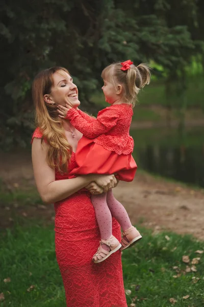 Happy mother with daughter in red dresses — Stock Photo, Image