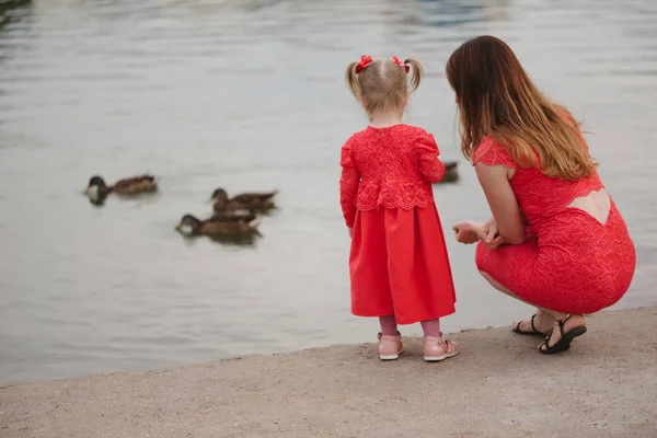 Mãe com filha alimentando patos no parque — Fotografia de Stock