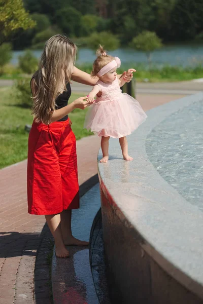 Young mother with daughter at fountain — Stock Photo, Image