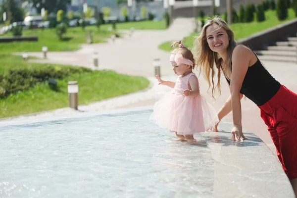 Young mother with daughter at fountain — Stock Photo, Image