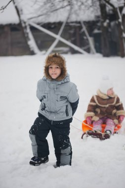 Çocuk kızakları ile kız kardeşi çeker.
