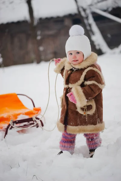 Ragazza carina con slitta nella neve — Foto Stock