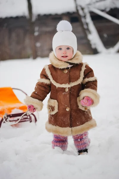 Ragazza carina con slitta nella neve — Foto Stock