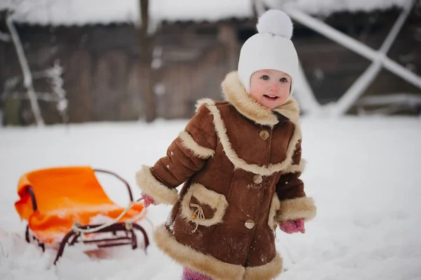 Cute girl with sled in snow — Stock Photo, Image