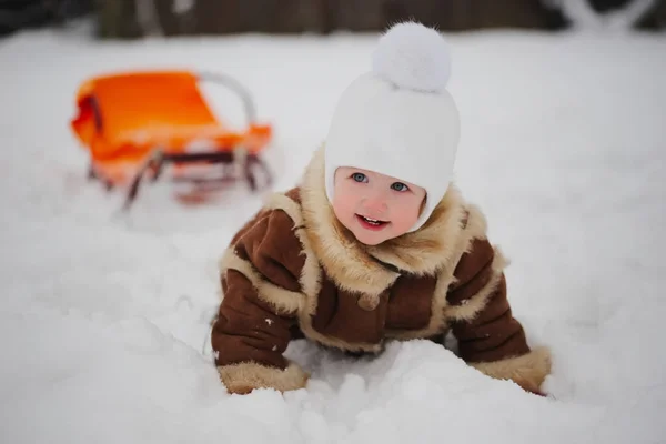 Jolie fille avec traîneau dans la neige — Photo