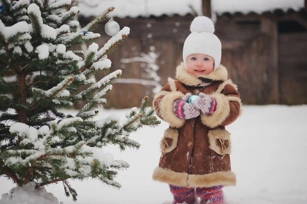 Tyttö koristelu joulukuusi n pihalla — kuvapankkivalokuva