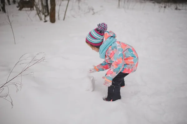 Κορίτσι κάνει χιονάνθρωπος χειμώνα πάρκο — Φωτογραφία Αρχείου