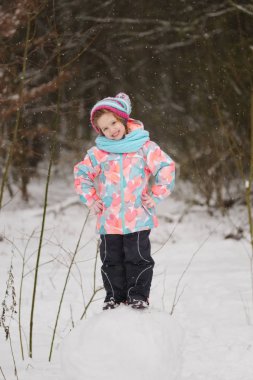 Kız kardan adam kış parkta yapar.