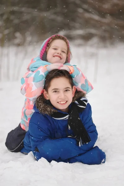 Κορίτσι και αγόρι, που βρίσκεται στο χιόνι — Φωτογραφία Αρχείου