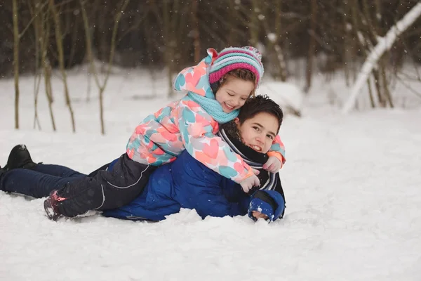 女孩和男孩躺在雪地上 — 图库照片