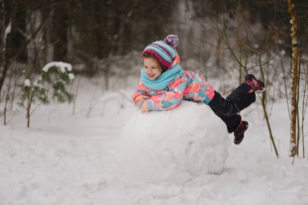 Dziewczyna sprawia, że snowman w winter park — Zdjęcie stockowe