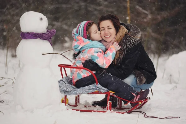 Beautiful mother with daughter in winter park — Stock Photo, Image