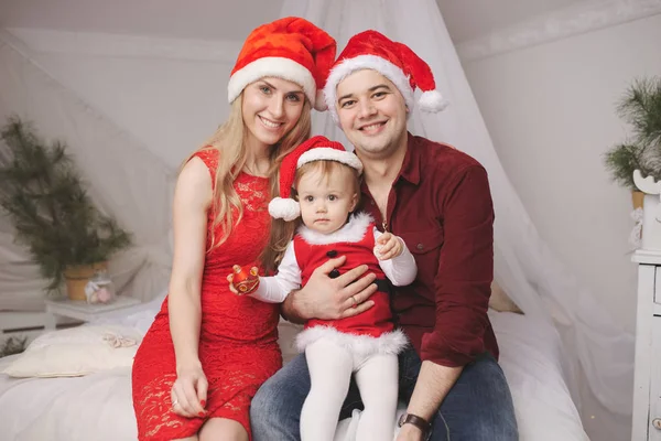 Familie mit Weihnachtsmützen zu Hause — Stockfoto