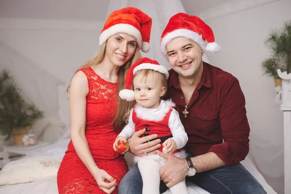 Familie mit Weihnachtsmützen zu Hause — Stockfoto