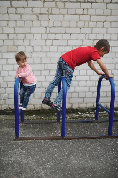 Pojke och flicka klättra på cykelparkering — Stockfoto