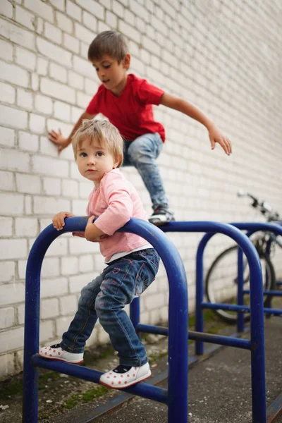 Junge und Mädchen klettern auf Fahrradparkplatz — Stockfoto