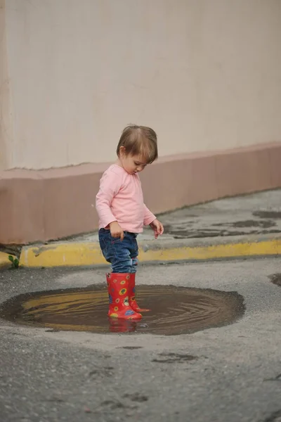 Girl plays in the puddle outdoors — Stock Photo, Image