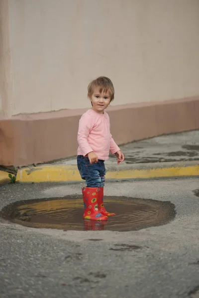 Girl plays in the puddle outdoors — Stock Photo, Image