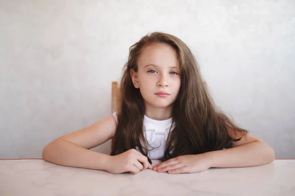 Menina sentada à mesa — Fotografia de Stock