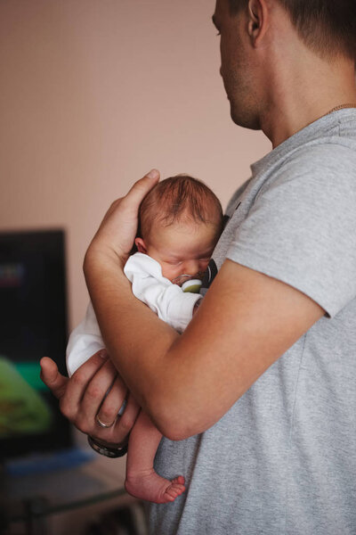 happy father holds newborn son