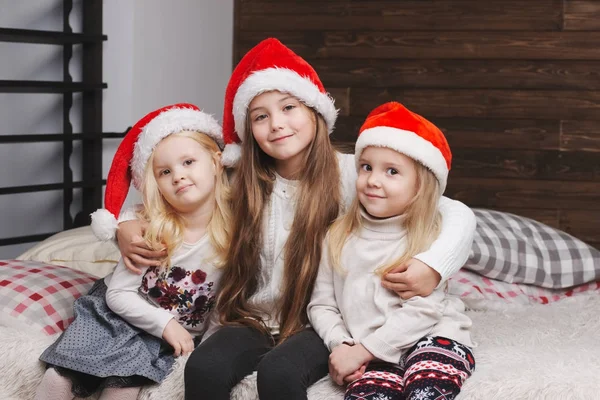 Niedliche glückliche Kinder mit Weihnachtsmützen — Stockfoto