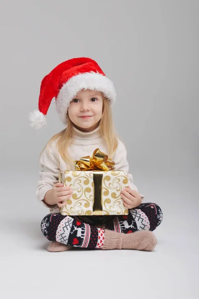 Kleines glückliches Mädchen mit Weihnachtsmütze — Stockfoto