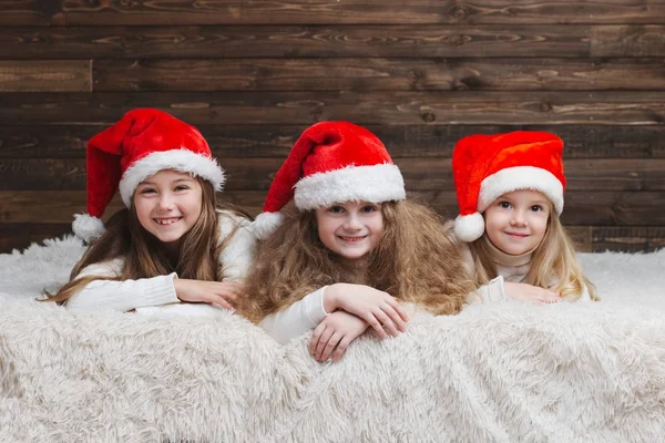 Crianças felizes bonito com chapéus de santa — Fotografia de Stock