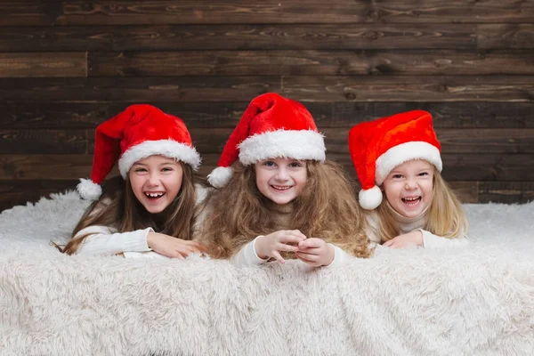 Crianças felizes bonito com chapéus de santa — Fotografia de Stock