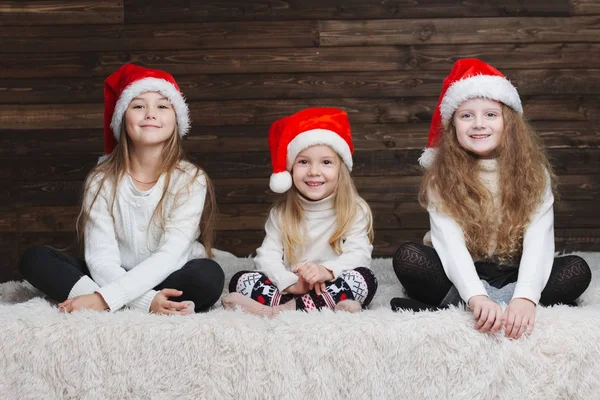 Niedliche glückliche Kinder mit Weihnachtsmützen — Stockfoto