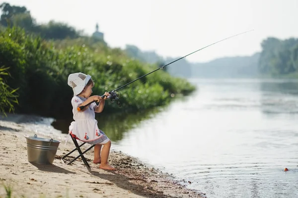 愉快的女孩与棍子在河的海岸 — 图库照片