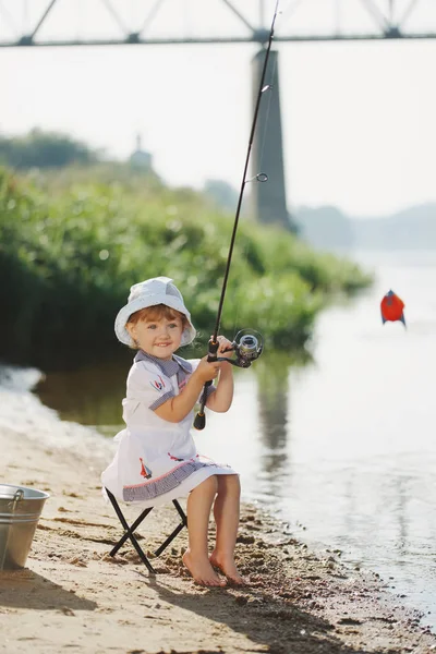 Счастливая девушка с удочкой на берегу реки — стоковое фото