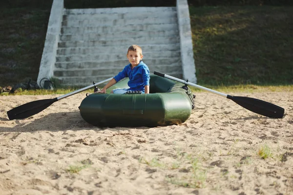 Petit garçon nageant en bateau sur la plage de sable — Photo