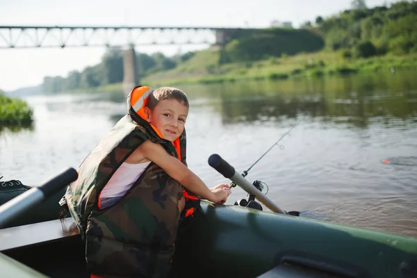 Gelukkige jongen zwemmen in vissersboot — Stockfoto