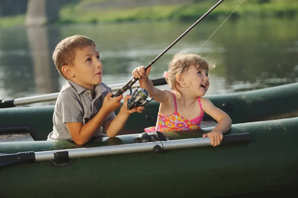 Happy boy swimming in fishing boat — Stock Photo, Image