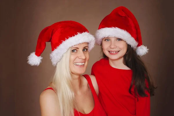 Beautiful mother and daughter with santa hats — Stock Photo, Image