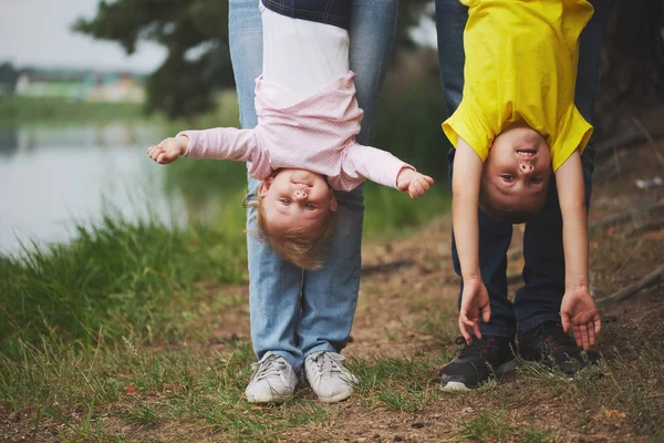 Mother and father holding son and daughter upside down — Stock Photo, Image