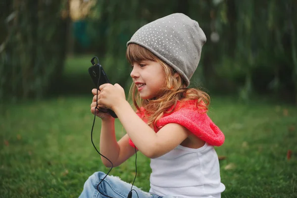 Petite fille avec téléphone portable sur l'herbe — Photo