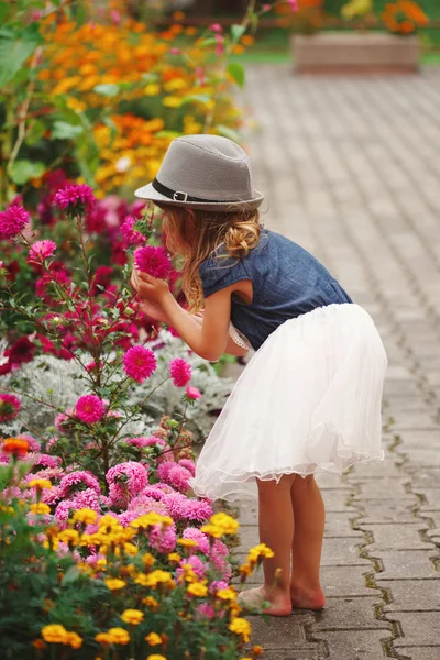 Little beautiful girl in flowers park — Stock Photo, Image