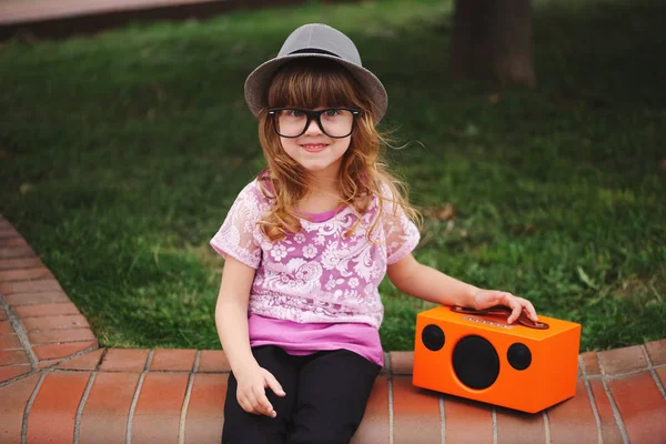 Pequeña hipster chica escucha música en inalámbrico retro buscando spea —  Fotos de Stock