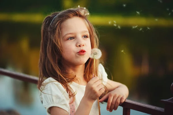 Niña con diente de león en el parque — Foto de Stock