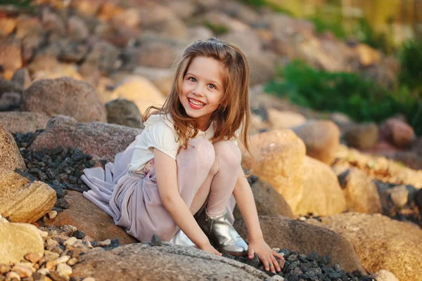 Petite fille jouer sur la plage de pierres — Photo