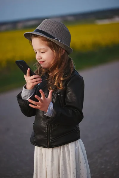 Маленькая смешная девочка со смартфоном — стоковое фото