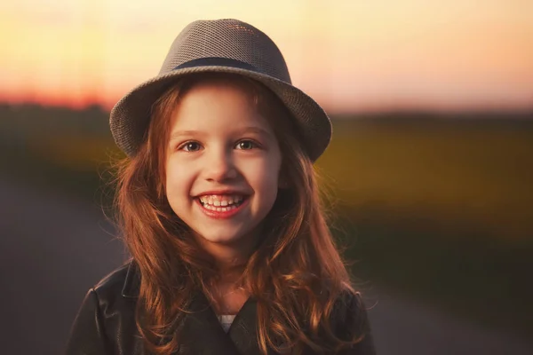 美丽的女孩与帽子在黄昏日落 — 图库照片