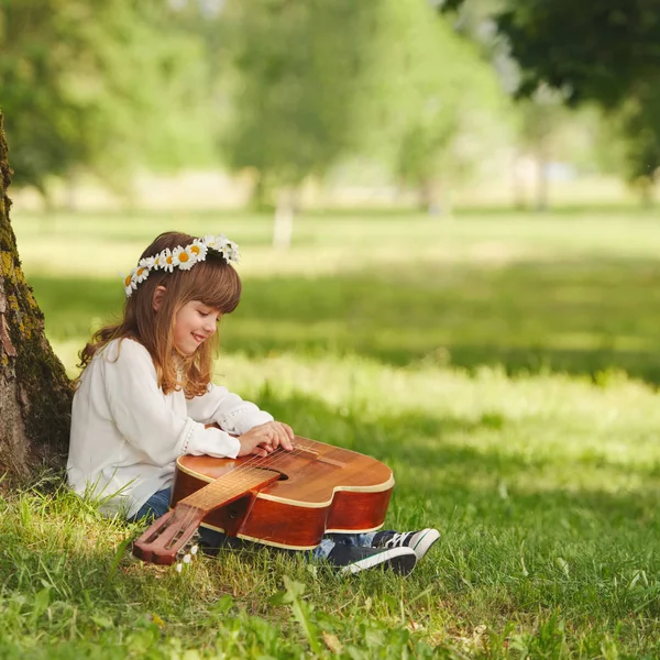 Garçon et fille jouer de la guitare dans le parc d'été — Photo