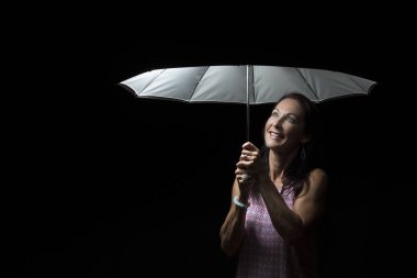 Geceleri bir şemsiye altında pembe elbise ile güzel kadın