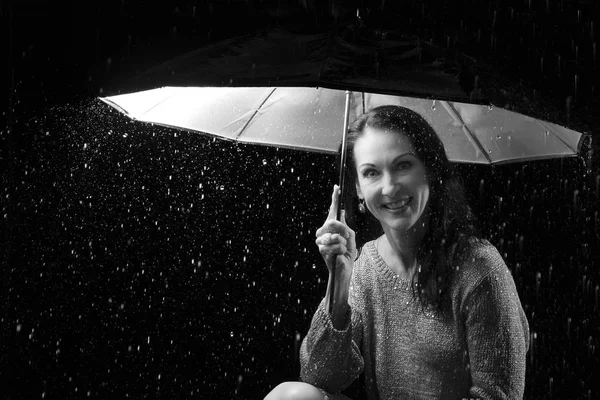 Ezüst ruha alatt egy esernyő-n ülve a gyönyörű nő — Stock Fotó
