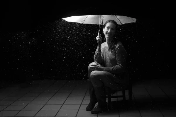 Όμορφη γυναίκα με ασημί φόρεμα κάθεται κάτω από μια ομπρέλα στο ν — Φωτογραφία Αρχείου