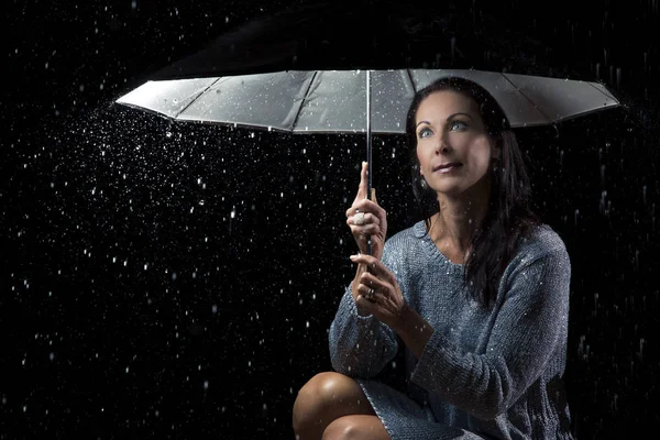 Ezüst ruha alatt egy esernyő-n ülve a gyönyörű nő — Stock Fotó